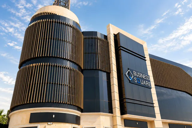 Vertical metal fin system wrapping the curved drums of Business Square