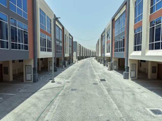 Aerial view along a street of the Wardana townhouse community in Ajman